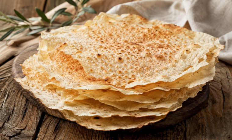 Dünnes knuspriges Pane Carasau auf einem rustikalen sardischen Tisch